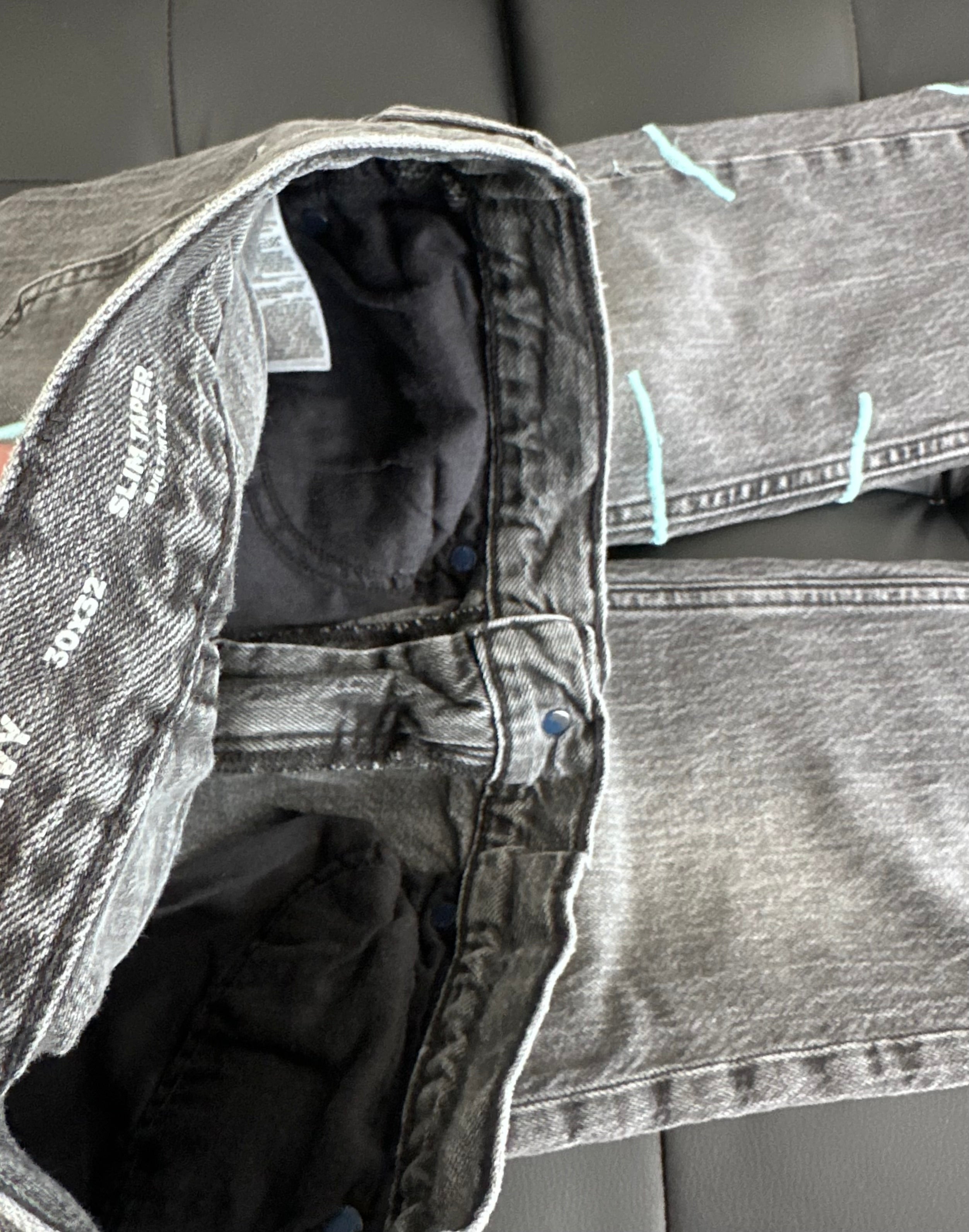 Grey slim taper jeans with a teal embroidered web