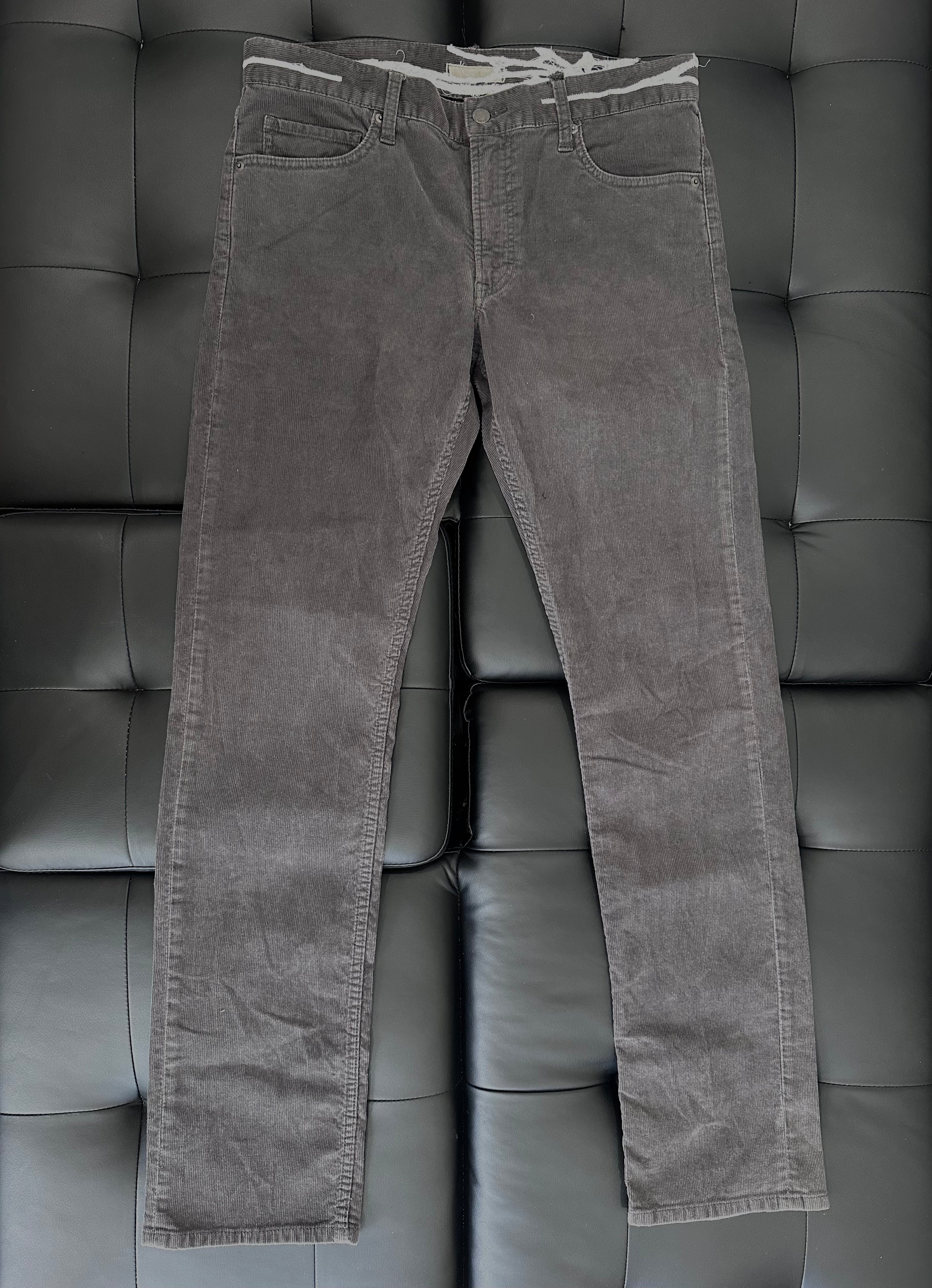 Grey corduroy pants with web embroidered around the waist