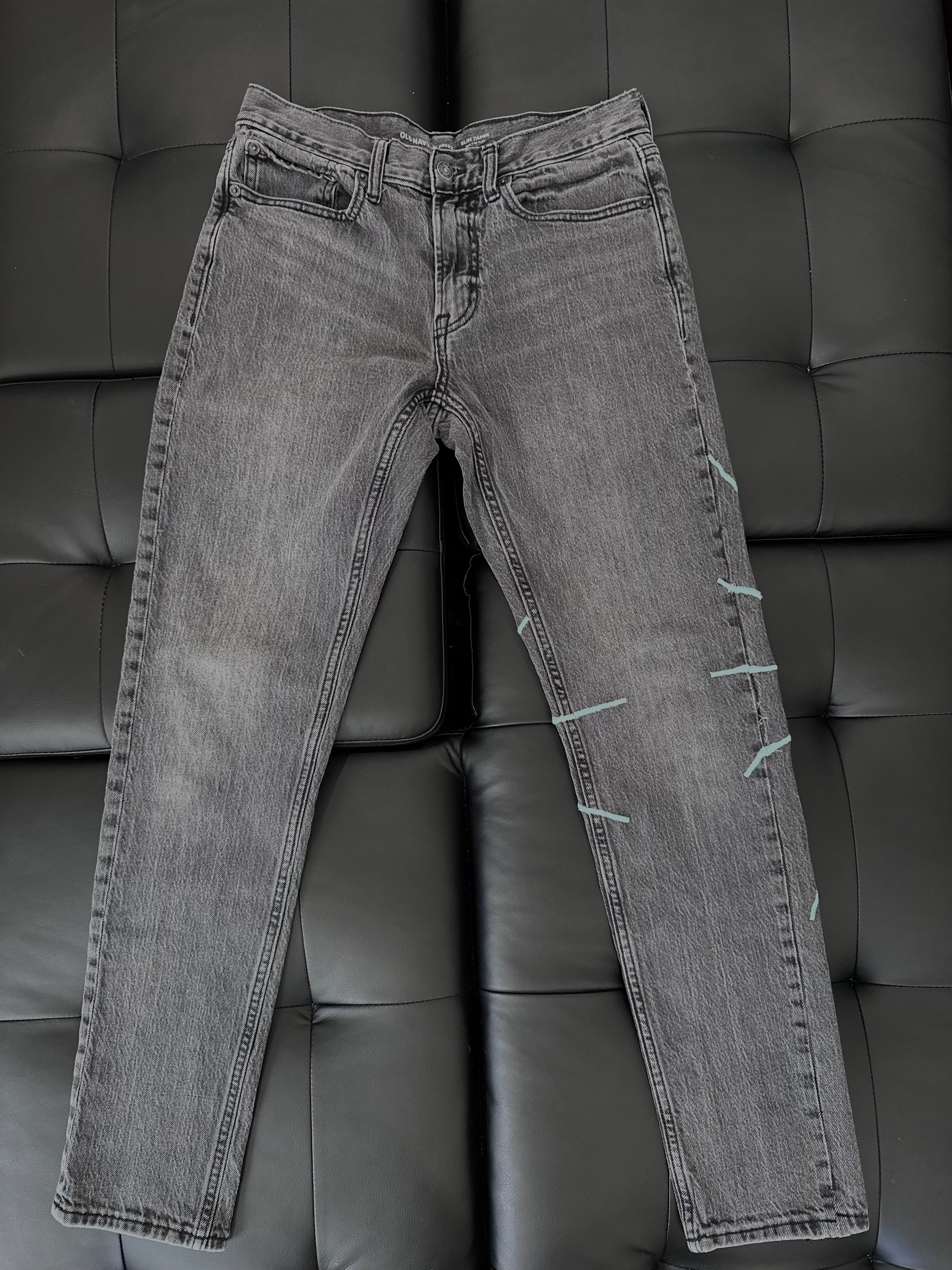 Grey slim taper jeans with a teal embroidered web